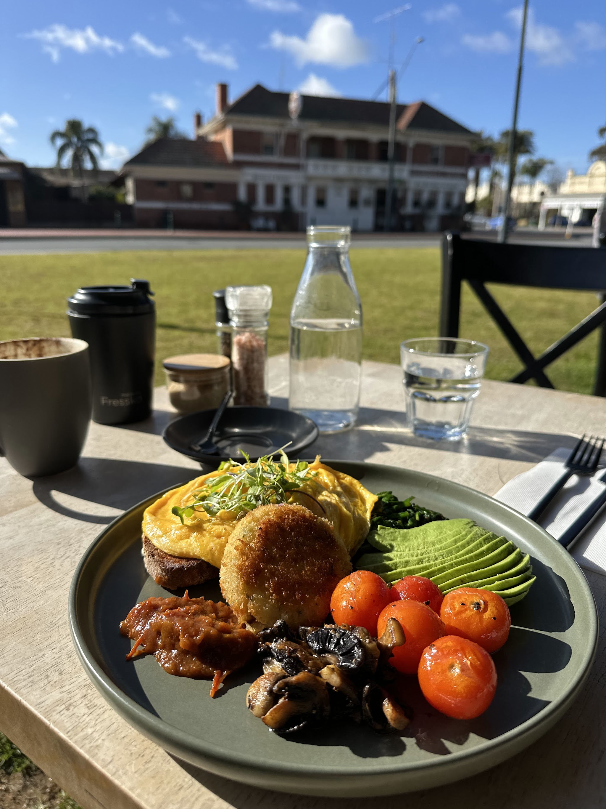 Big breakfast plate with eggs, hash cake, avocado, tomatoes and mushrooms